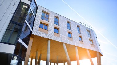 Eşsiz bir mimari çözümü olan bir apartman. Beyaz cepheli ve yüksek beton sütunların üzerinde duran modern bir yerleşim yeri..