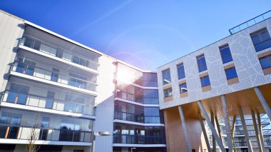 Eşsiz bir mimari çözümü olan bir apartman. Beyaz cepheli ve yüksek beton sütunların üzerinde duran modern bir yerleşim yeri..