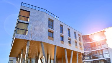 Eşsiz bir mimari çözümü olan bir apartman. Beyaz cepheli ve yüksek beton sütunların üzerinde duran modern bir yerleşim yeri..