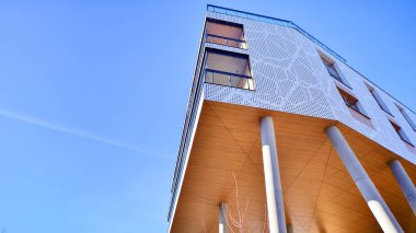 Eşsiz bir mimari çözümü olan bir apartman. Beyaz cepheli ve yüksek beton sütunların üzerinde duran modern bir yerleşim yeri..