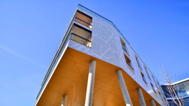 Eşsiz bir mimari çözümü olan bir apartman. Beyaz cepheli ve yüksek beton sütunların üzerinde duran modern bir yerleşim yeri..