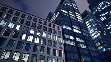 Geceleri ofis binaları. Gece mimarisi, cam yüzlü binalar. İş bölgesindeki modern binalar. Ekonomi kavramı, mali.
