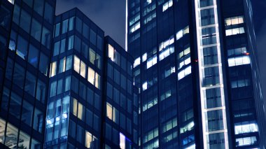 Geceleri ofis binaları. Gece mimarisi, cam yüzlü binalar. İş bölgesindeki modern binalar. Ekonomi kavramı, mali.