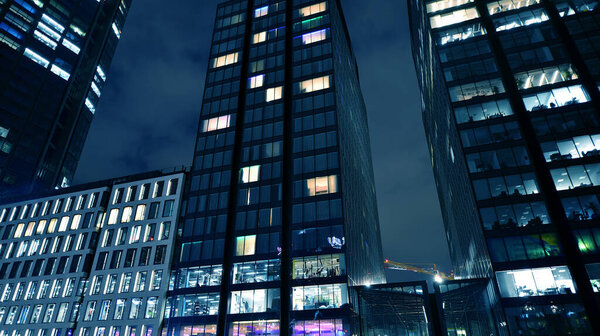 Office buildings by night. Night architectural, buildings with glass facade. Modern buildings in business district. Concept of economics, financial.