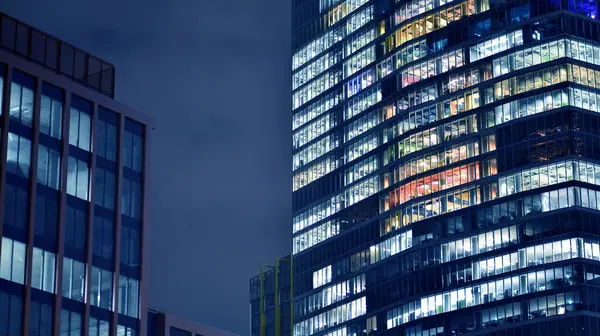 Geceleri ofis binaları. Gece mimarisi, cam yüzlü binalar. İş bölgesindeki modern binalar. Ekonomi kavramı, mali.