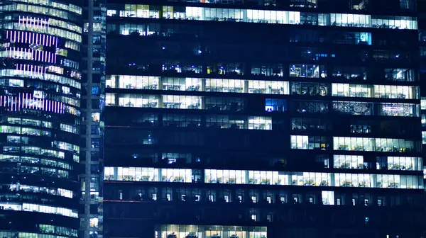 Geceleri ofis binaları. Gece mimarisi, cam yüzlü binalar. İş bölgesindeki modern binalar. Ekonomi kavramı, mali.