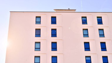 Beyaz, modern bir apartman manzarası. Mavi gökyüzü ile mükemmel bir simetri. Geometrik mimari modern beton yapı yapısını detaylandırıyor. Soyut somut mimari. 