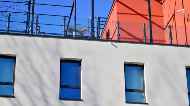 Beyaz, modern bir apartman manzarası. Mavi gökyüzü ile mükemmel bir simetri. Geometrik mimari modern beton yapı yapısını detaylandırıyor. Soyut somut mimari. 