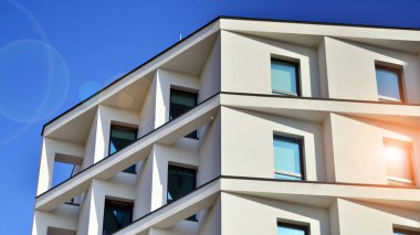 Beyaz, modern bir apartman manzarası. Mavi gökyüzü ile mükemmel bir simetri. Geometrik mimari modern beton yapı yapısını detaylandırıyor. Soyut somut mimari. 