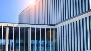 Şehrin modern ofis binası. Pencereleri, çeliği ve alüminyum panelleri var. Çağdaş ticari mimari, dikey geometrik çizgiler.