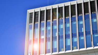 Şehrin modern ofis binası. Pencereleri, çeliği ve alüminyum panelleri var. Çağdaş ticari mimari, dikey geometrik çizgiler.