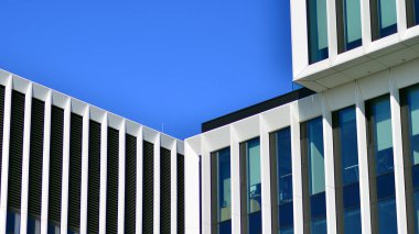 Şehrin modern ofis binası. Pencereleri, çeliği ve alüminyum panelleri var. Çağdaş ticari mimari, dikey geometrik çizgiler.