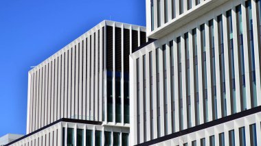 Şehrin modern ofis binası. Pencereleri, çeliği ve alüminyum panelleri var. Çağdaş ticari mimari, dikey geometrik çizgiler.