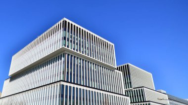 Şehrin modern ofis binası. Pencereleri, çeliği ve alüminyum panelleri var. Çağdaş ticari mimari, dikey geometrik çizgiler.