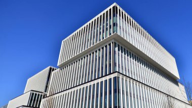 Şehrin modern ofis binası. Pencereleri, çeliği ve alüminyum panelleri var. Çağdaş ticari mimari, dikey geometrik çizgiler.