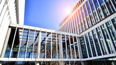 Şehrin modern ofis binası. Pencereleri, çeliği ve alüminyum panelleri var. Çağdaş ticari mimari, dikey geometrik çizgiler.