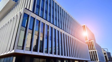 Şehrin modern ofis binası. Pencereleri, çeliği ve alüminyum panelleri var. Çağdaş ticari mimari, dikey geometrik çizgiler.