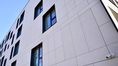 Beyaz, modern bir apartman manzarası. Mavi gökyüzü ile mükemmel bir simetri. Geometrik mimari modern beton yapı yapısını detaylandırıyor. Soyut somut mimari. 