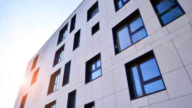 Beyaz, modern bir apartman manzarası. Mavi gökyüzü ile mükemmel bir simetri. Geometrik mimari modern beton yapı yapısını detaylandırıyor. Soyut somut mimari. 