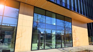 Modern Business City ofis binasının girişi. Modern şehir mimarisi. Ofis bloğunun ön kapısı, camdaki binaları yansıtıyor..