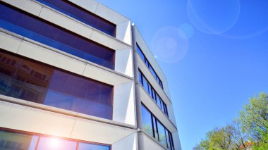 Çevre mimarisi. Yeşil ağaç ve yeni konut binası. Doğanın ve modernliğin ahengi. Yeşil yerleşim bölgesinde yeni daireleri olan modern bir apartman..