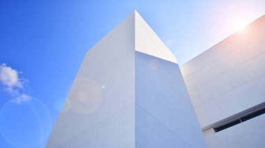 Beyaz Beton Binası 'nın yüzeyinde güneş ışığı ve gölge mavi gökyüzü arka planına karşı duvar, Minimal Sokak fotoğrafçılık tarzında Geometrik Dış Mimari