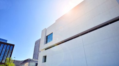 Sunlight and shadow on surface of white Concrete Building wall against blue sky background, Geometric Exterior Architecture in Minimal Street photography style clipart