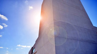 Beyaz Beton Binası 'nın yüzeyinde güneş ışığı ve gölge mavi gökyüzü arka planına karşı duvar, Minimal Sokak fotoğrafçılık tarzında Geometrik Dış Mimari