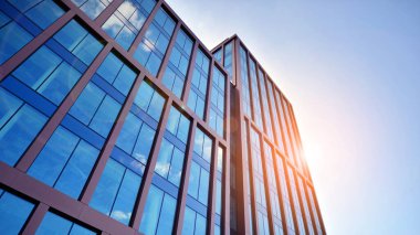 Binanın şeffaf yüzüyle cam bina ve mavi gökyüzü. Yapısal cam duvar mavi gökyüzünü yansıtıyor. Soyut modern mimari parçası. Çağdaş mimari arka plan.