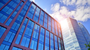 Binanın şeffaf yüzüyle cam bina ve mavi gökyüzü. Yapısal cam duvar mavi gökyüzünü yansıtıyor. Soyut modern mimari parçası. Çağdaş mimari arka plan.