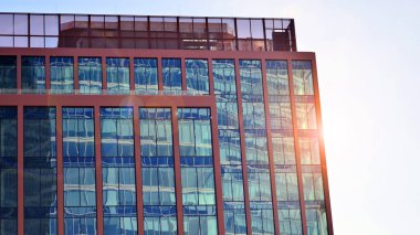 Binanın şeffaf yüzüyle cam bina ve mavi gökyüzü. Yapısal cam duvar mavi gökyüzünü yansıtıyor. Soyut modern mimari parçası. Çağdaş mimari arka plan.