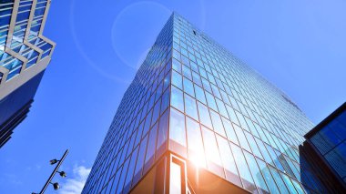 Çelik ve cam. Modern mimari ya da inşaat endüstrisinin konusu. Modern ofis binası cephesi yüksek çelik yapı elemanları ve tam boy pencereler arasında.