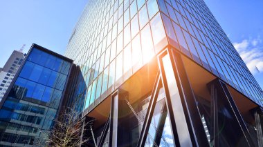 Çelik ve cam. Modern mimari ya da inşaat endüstrisinin konusu. Modern ofis binası cephesi yüksek çelik yapı elemanları ve tam boy pencereler arasında.