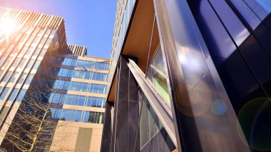 Çelik ve cam. Modern mimari ya da inşaat endüstrisinin konusu. Modern ofis binası cephesi yüksek çelik yapı elemanları ve tam boy pencereler arasında.