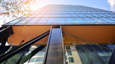 Çelik ve cam. Modern mimari ya da inşaat endüstrisinin konusu. Modern ofis binası cephesi yüksek çelik yapı elemanları ve tam boy pencereler arasında.