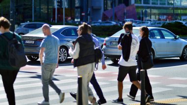 Varşova, Polonya. 11 Nisan 2024. Kalabalık kalabalık trafiğin en yoğun olduğu saatte trafik ışığı zebrasıyla karşıdan karşıya geçiyor. Europa 'da büyük bir şehirde yaşam tarzı.