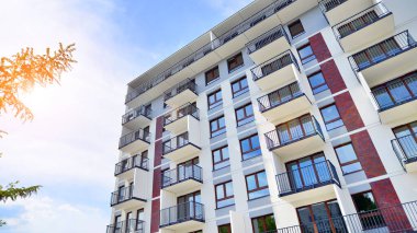Yeşil yerleşim bölgesinde yeni daireleri olan modern bir yerleşim yeri. Çevre mimarisi. Yeşil ağaç ve yeni apartman. Doğanın ve modernliğin ahengi.