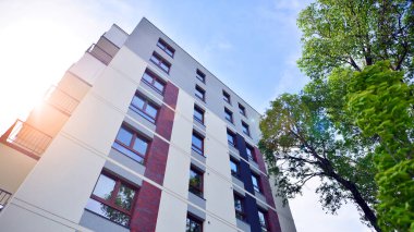 Modern residential building with new apartments in a green residential area. Eco architecture. Green tree and new apartment building. The harmony of nature and modernity.