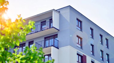 Yeşil yerleşim bölgesinde yeni daireleri olan modern bir yerleşim yeri. Çevre mimarisi. Yeşil ağaç ve yeni apartman. Doğanın ve modernliğin ahengi.