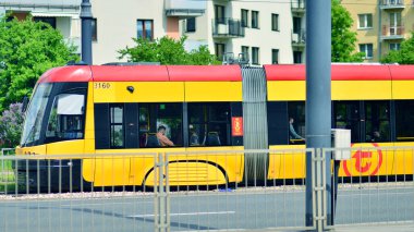 Varşova, Polonya. 28 Nisan 2024. Sokaktaki modern kırmızı ve sarı tramvaylar. Toplu taşıma.