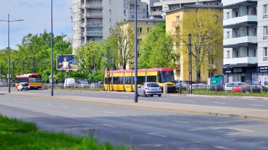 Varşova, Polonya. 28 Nisan 2024. Sokaktaki modern kırmızı ve sarı tramvaylar. Toplu taşıma.