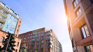 Modern residential building with new apartments in a green residential area. Eco architecture. Green tree and new apartment building. The harmony of nature and modernity.