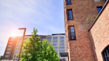 Modern residential building with new apartments in a green residential area. Eco architecture. Green tree and new apartment building. The harmony of nature and modernity.