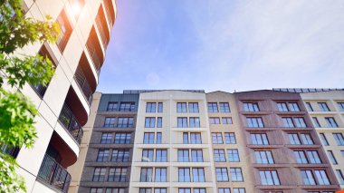 Modern residential building with new apartments in a green residential area. Eco architecture. Green tree and new apartment building. The harmony of nature and modernity.