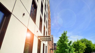 Modern residential building with new apartments in a green residential area. Eco architecture. Green tree and new apartment building. The harmony of nature and modernity.