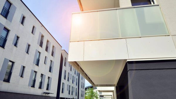 Contemporary residential building exterior in the daylight. Modern apartment buildings on a sunny day with a blue sky. Facade of a modern apartment building