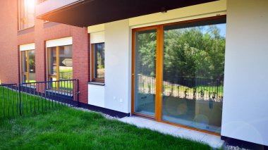 Yeşil çimleri ve rahatlayacağı bir yeri olan modern bir yerleşim yerinin bahçesi..