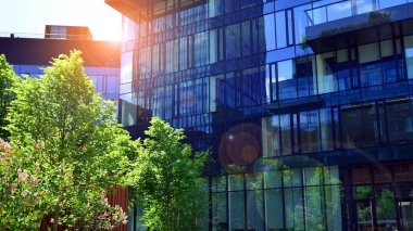 Karbondioksiti azaltmak için ağaçlı sürdürülebilir cam ofis binası. Modern şehirde çevre dostu bir bina. Yeşil çevresi olan bir ofis. Şirket binası CO2 'yi düşürdü.