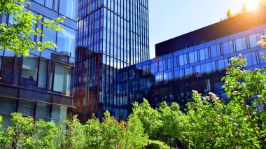 Karbondioksiti azaltmak için ağaçlı sürdürülebilir cam ofis binası. Modern şehirde çevre dostu bir bina. Yeşil çevresi olan bir ofis. Şirket binası CO2 'yi düşürdü.