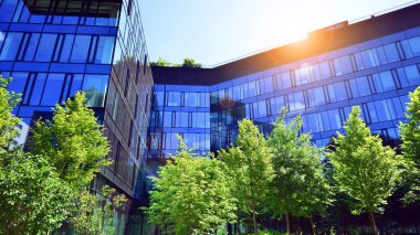 Karbondioksiti azaltmak için ağaçlı sürdürülebilir cam ofis binası. Modern şehirde çevre dostu bir bina. Yeşil çevresi olan bir ofis. Şirket binası CO2 'yi düşürdü.